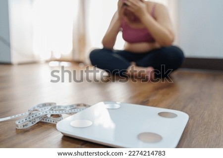 Obese Woman with fat upset bored of dieting Weight loss fail  Fat diet and scale sad asian woman on weight scale at home weight control