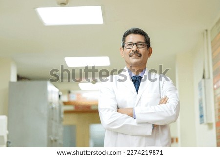 Confident Indian male doctor standing at hospital.