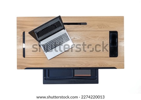 Office wooden dark brown desk table with computer, supplies and open drawer. Top view with copy space isolated on white