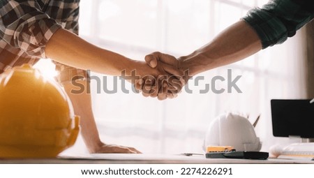 Construction workers, architects and engineers shake hands while working for teamwork and cooperation after completing an agreement in an office facility, successful cooperation concept. Royalty-Free Stock Photo #2274226291