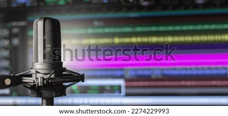 Professional vocal microphone with audio editing software background and copy space for podcast or radio broadcast banner Royalty-Free Stock Photo #2274229993