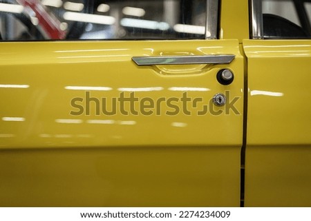 A close up look at yellow classic car. Retro automobile exterior scene. Side view of old vehicle.