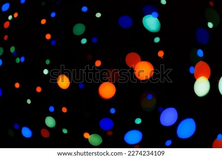 Bokeh from multi-colored garland light bulbs or colored disco lights.