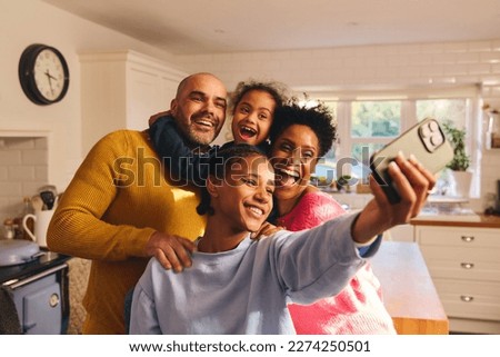 Teen girl taking selfie on phone with happy smiling family Royalty-Free Stock Photo #2274250501