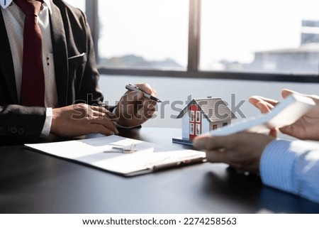 Real estate agent talked about the terms of the home purchase agreement and asked the customer to sign the documents to make the contract legally, Home insurance, loan, mortgage, rent.