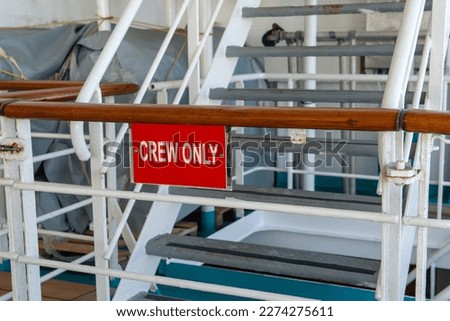A ships restricted area steel rod gate finished with teak wood top railing. Crew area only passengers do not enter. Royalty-Free Stock Photo #2274275611