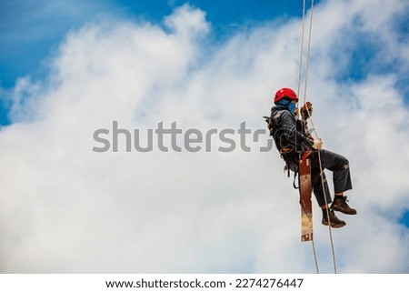 Closeup male worker swings on tank male worker height roof tank knot carabiner rope access safety inspection. Royalty-Free Stock Photo #2274276447
