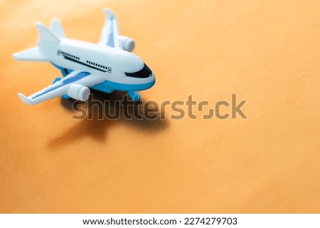 Airplane model. White plane on orange background. Travel vacation concept. Summer background. Flat lay, top view, copy space.