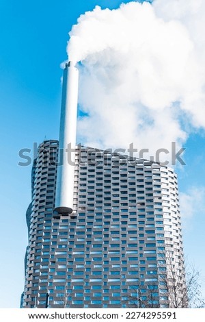 building with big chimney emitting smoke