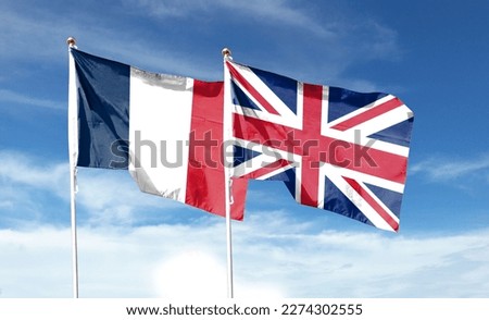 Union Jack and French flag on cloudy sky. waving in the sky