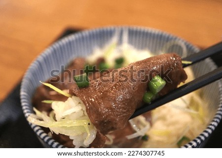 Beef tongue roast is a staple dish in Sendai City. This picture shows a bowl of beef tongue with green onions.