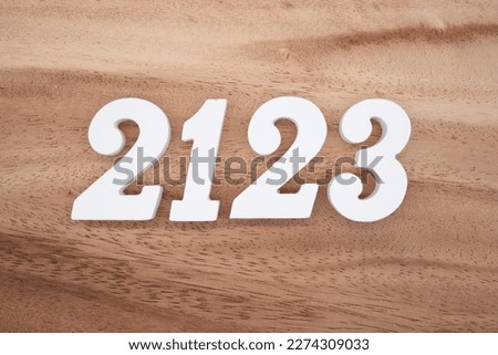 White number 2123 on a brown and light brown wooden background.