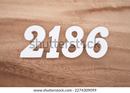 White number 2186 on a brown and light brown wooden background.