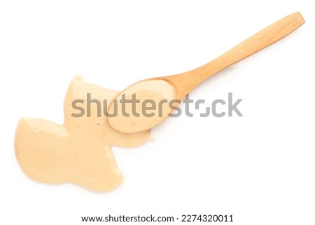 Wooden spoon with tasty tahini on white background Royalty-Free Stock Photo #2274320011