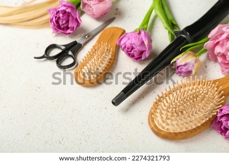 Hairdresser's tools with tulips on white background, closeup. Hello spring