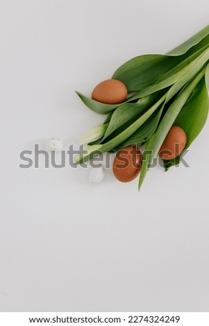 Bouquet of white tulips and eggs on a white background.  Easter spring background.  Spring picture on a light canvas. Mock up for Easter
