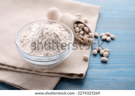 Kidney bean flour and seeds on light blue wooden table, closeup