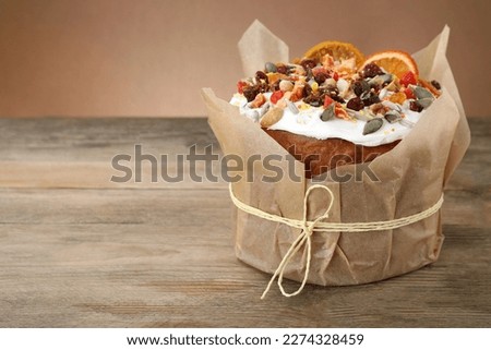Traditional Easter cake with dried fruits on wooden table, space for text
