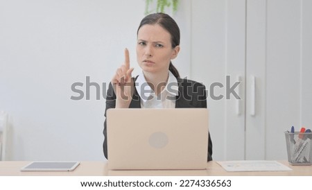 Young Businesswoman Shaking Head in Rejection while Working on Laptop