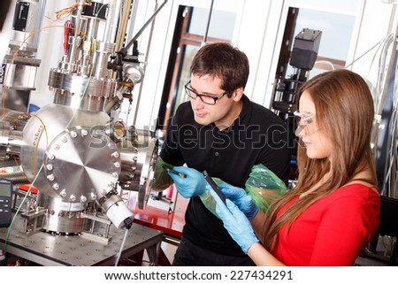 Scientists working with laser deposition chamber Royalty-Free Stock Photo #227434291