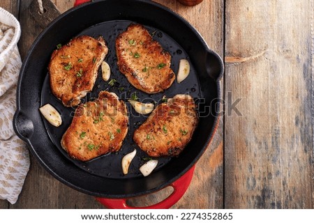 Pork chops cooked with garlic in a cast iron pan Royalty-Free Stock Photo #2274352865