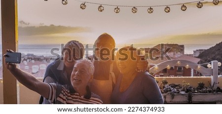 Group of senior friends enjoying leisure outdoor activity taking selfie picture  outside at home having fun and smiling. Elderly technology sharing pictures mature people lifestyle. Celebrating sunset