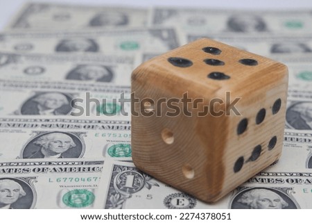 Gambling dice for money in a casino. Cube on one dollar bills. Underground and illegal gambling for money