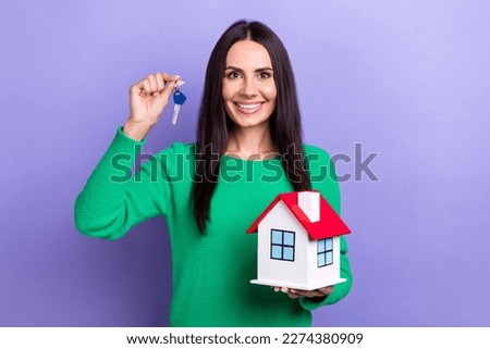 Photo of confident pretty lady dressed green sweater rising keys holding small house isolated violet color background