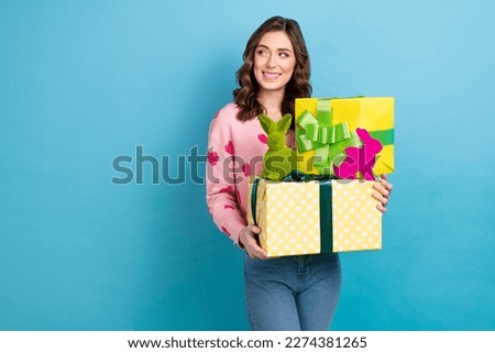 Photo of beautiful young positive girl hold stack gift boxes green handmade easter rabbit holiday look mockup ad isolated on blue color background