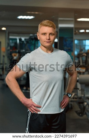blonde guy is working out in the gym