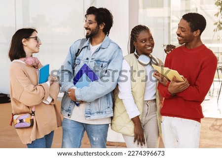 Laughing young diverse people students in casual with headphones, notebooks, communicate at spare time in university. Modern study, knowledge, education, break together in college and fun