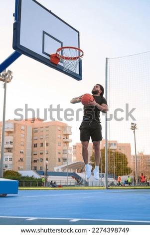 Afro-Latino man plays basketball and dunks the ball into a basket