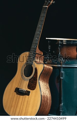 Acoustic guitar and snare drum on a black background isolated.