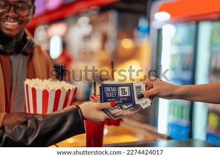 A close up shot of hands receiving tickets from a cash register clerk in the cinema. Royalty-Free Stock Photo #2274424017