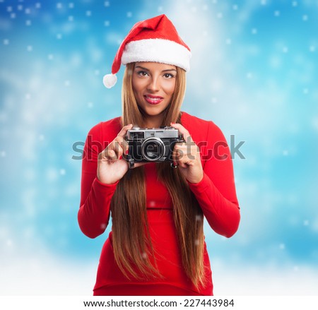 portrait of a beautiful young woman at Christmas taking a photo with her camera