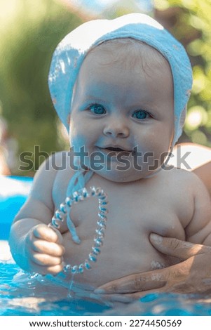 Small baby girl smiling and playing outdoor in sunny day. Blonde and blue eyes baby. Very beautifull baby girl outdoor summer day.