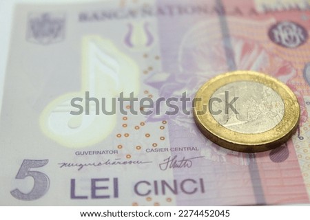 Close-up of one Euro coin on 5 lei romanian currency banknote Royalty-Free Stock Photo #2274452045