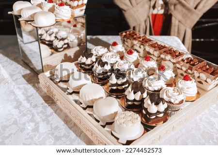 Candy bar. portion different cakes decorated on the festive table, strawberry tartlet and cupcakes. Wedding. Reception. Tartlets