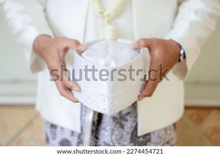 the groom's hand holds a white skullcap. Muslim wedding photo concept stock.