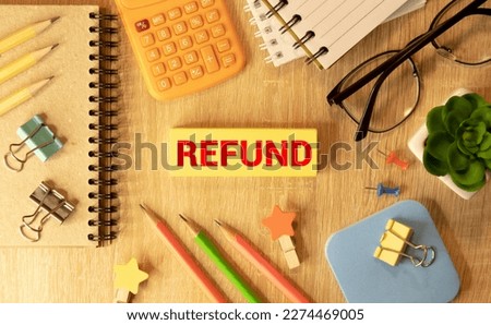 Letter block in word refund on wood background.