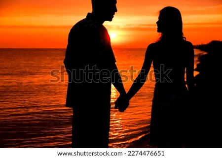 silhouette of a happy couple at sunrise on summer nature