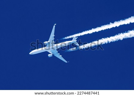 Sharp telephoto close-up of jet plane aircraft with contrails cruising from Hong Kong to New York, altitude AGL 37,000 feet, ground speed 588 knots. Royalty-Free Stock Photo #2274487441