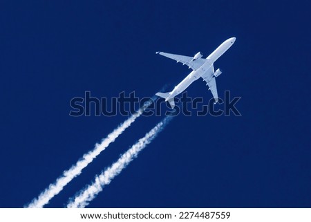Sharp telephoto close-up of jet plane aircraft with contrails cruising from Hong Kong to New York, altitude AGL 37,000 feet, ground speed 554 knots Royalty-Free Stock Photo #2274487559