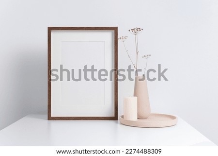 Vertical wooden poster frame in white interior, mockup for picture, print or photo frame presentation