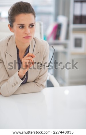 Portrait of thoughtful business woman with eyeglasses in office