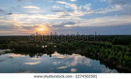 Aerial panorama Early Sunrise over forest lake. Noctilucent night clouds, summer foggy lake reflects sky. High quality photo
