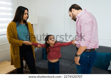 Upset sad man trying to take her young daughter with him while arguing about child custody with the mother after divorce Royalty-Free Stock Photo #2274520707