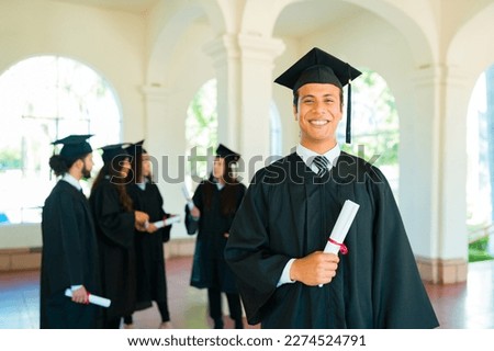 Happy hispanic young man feeling proud and happy about graduating and finishing his college education Royalty-Free Stock Photo #2274524791