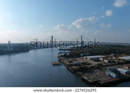The rippling blue waters of the Savannah River with the Talmadge Memorial Bridge over the water and hotels, office buildings and restaurants along the banks in Savannah Georgia USA