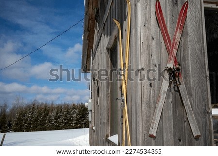 Sugar shack, old traditional barn in Quebec, Canada, surrounded by snow with vintage ski decoration Royalty-Free Stock Photo #2274534355